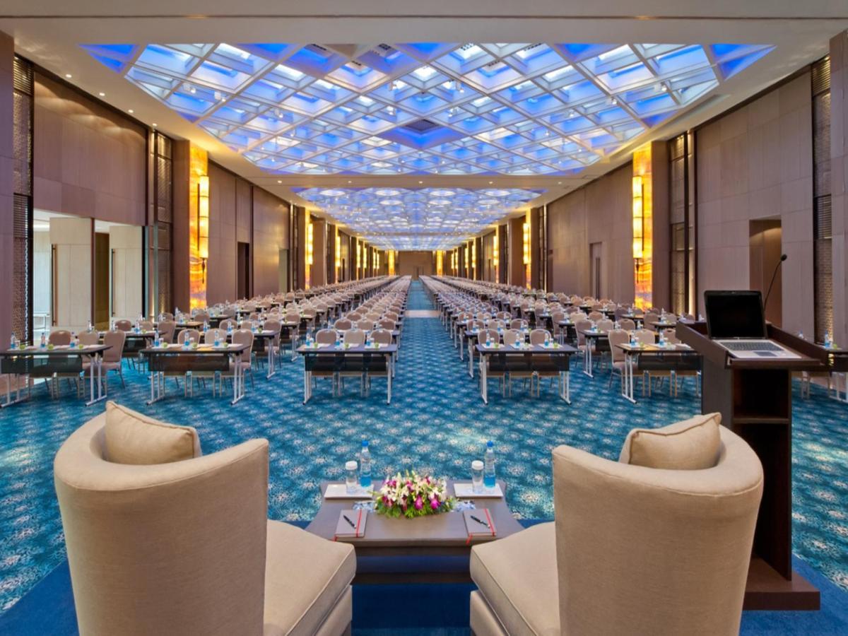 a large banquet hall with tables and chairs in the middle at The Leela Ambience Convention Hotel Delhi in New Delhi