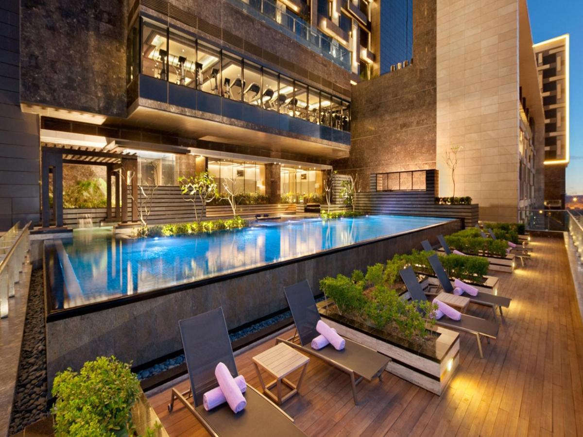 a hotel with a swimming pool and a building at The Leela Ambience Convention Hotel Delhi in New Delhi