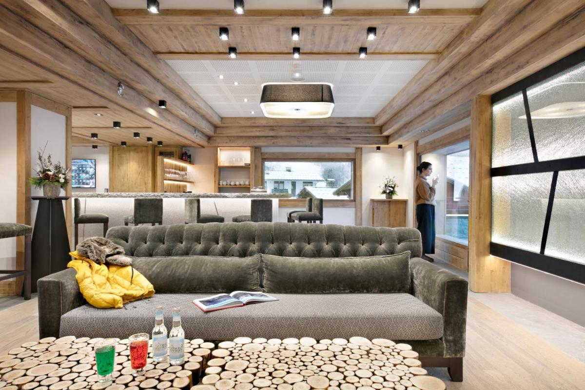 une salle d'attente avec un canapé et une table dans l'établissement MGM Hôtels & Résidences - Résidence Chalets Elena, aux Houches