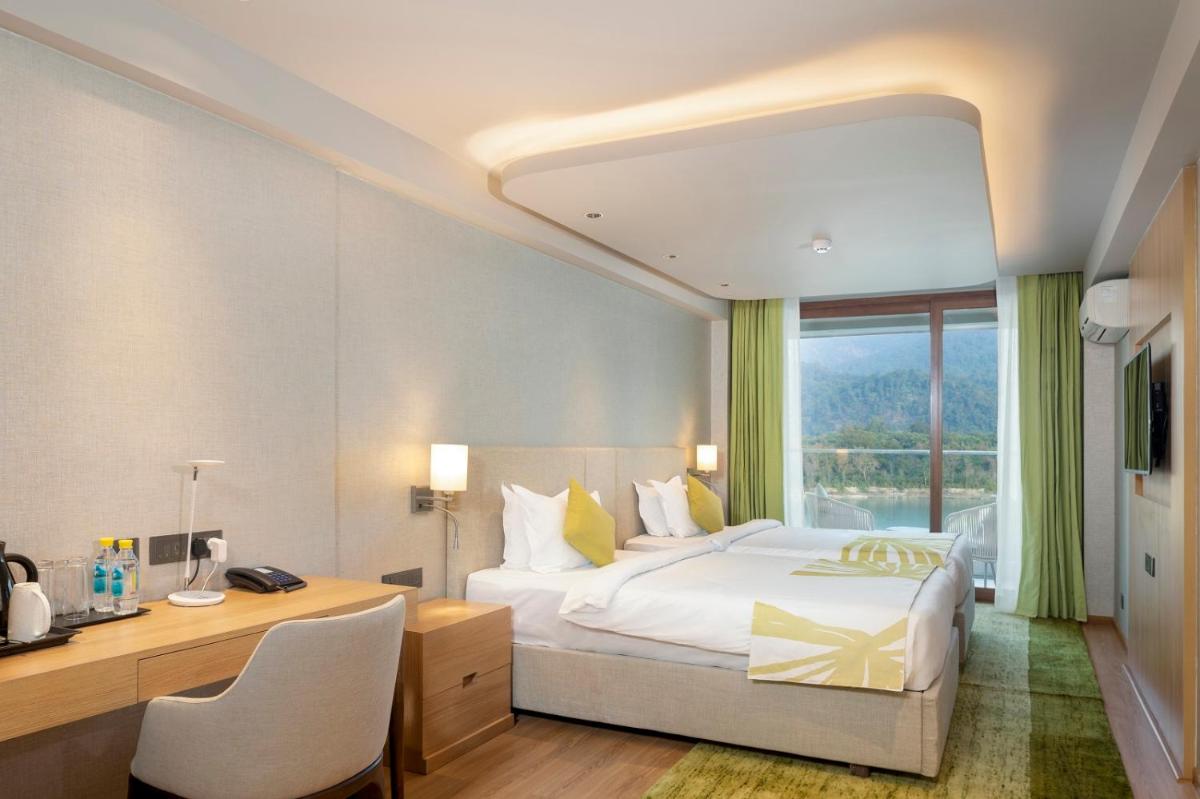 a bedroom with a bed and a desk and a window at Modi Yoga Retreat Rishikesh in Rishīkesh