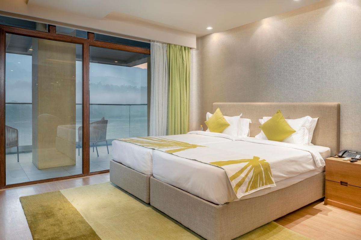 a bedroom with a large bed with yellow pillows at Modi Yoga Retreat Rishikesh in Rishīkesh