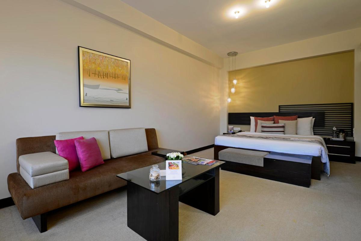 a hotel room with a bed and a couch at Sun-n-Sand Mumbai Juhu Beach in Mumbai