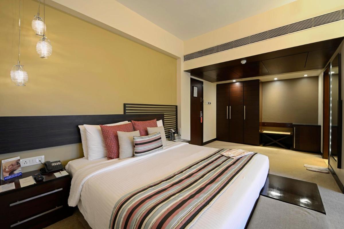 a large bedroom with a large bed and a television at Sun-n-Sand Mumbai Juhu Beach in Mumbai
