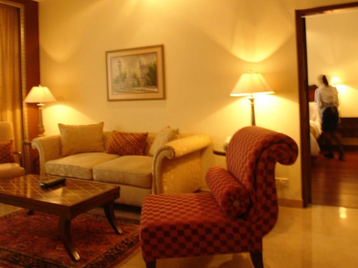 a living room with a couch and a chair at The Lalit Mumbai in Mumbai