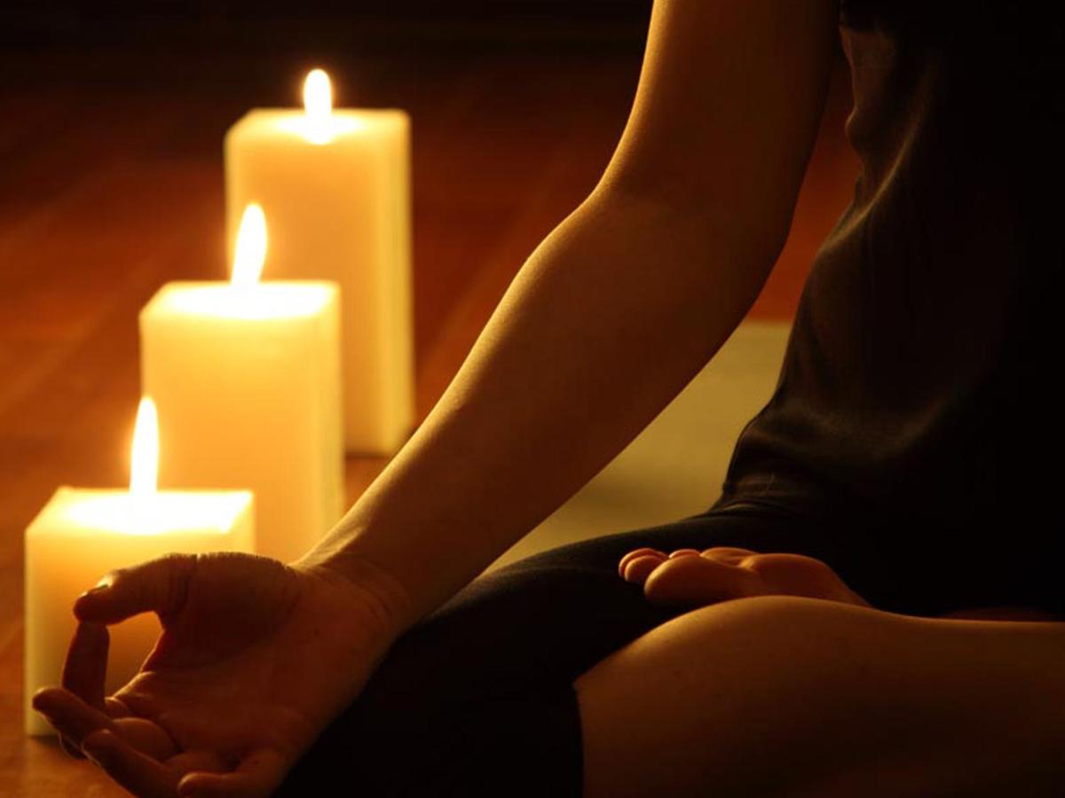 a woman sitting in front of two candles at The Lalit Mumbai in Mumbai