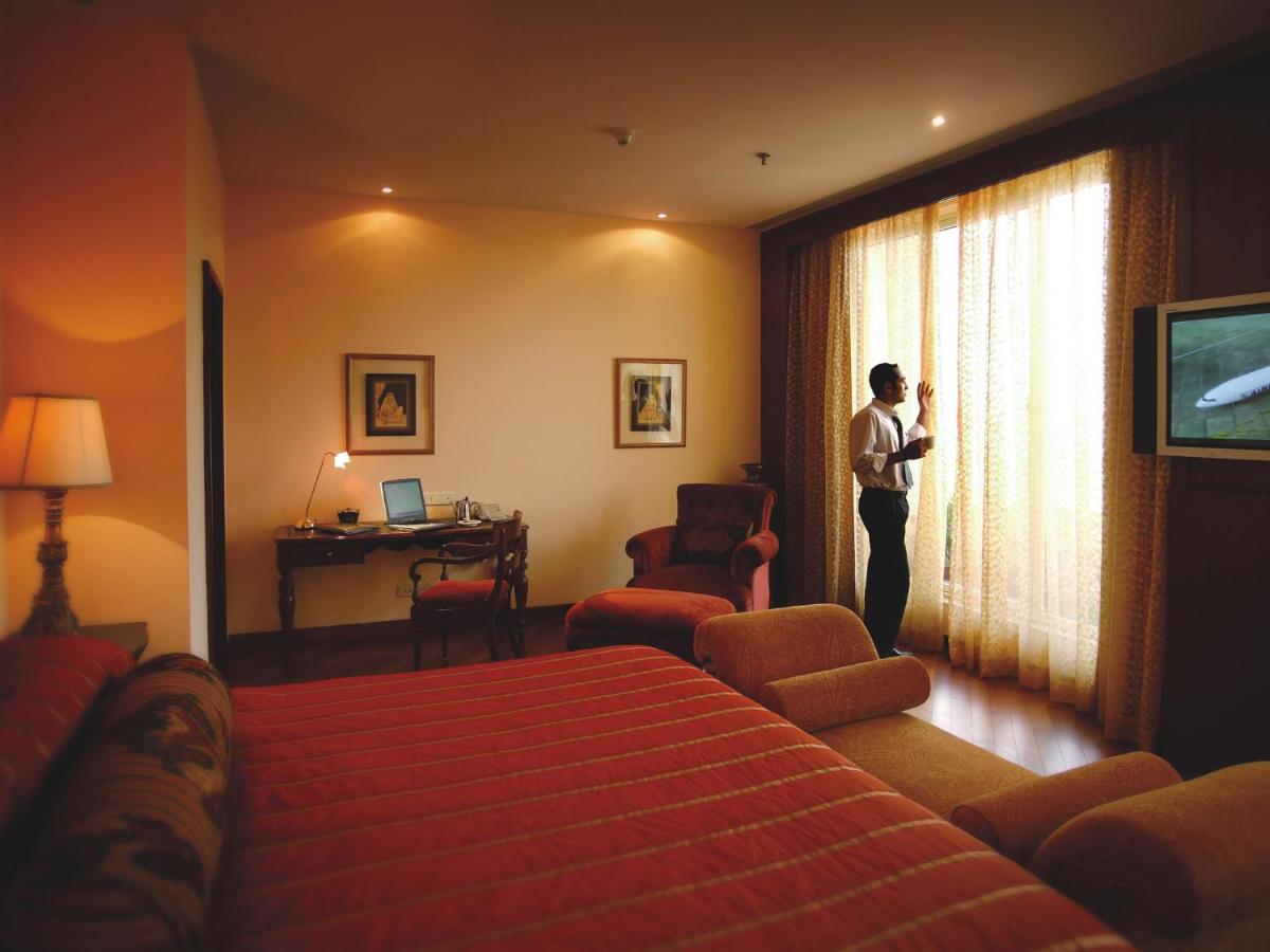 a person standing in a hotel room looking out the window at The Lalit Mumbai in Mumbai