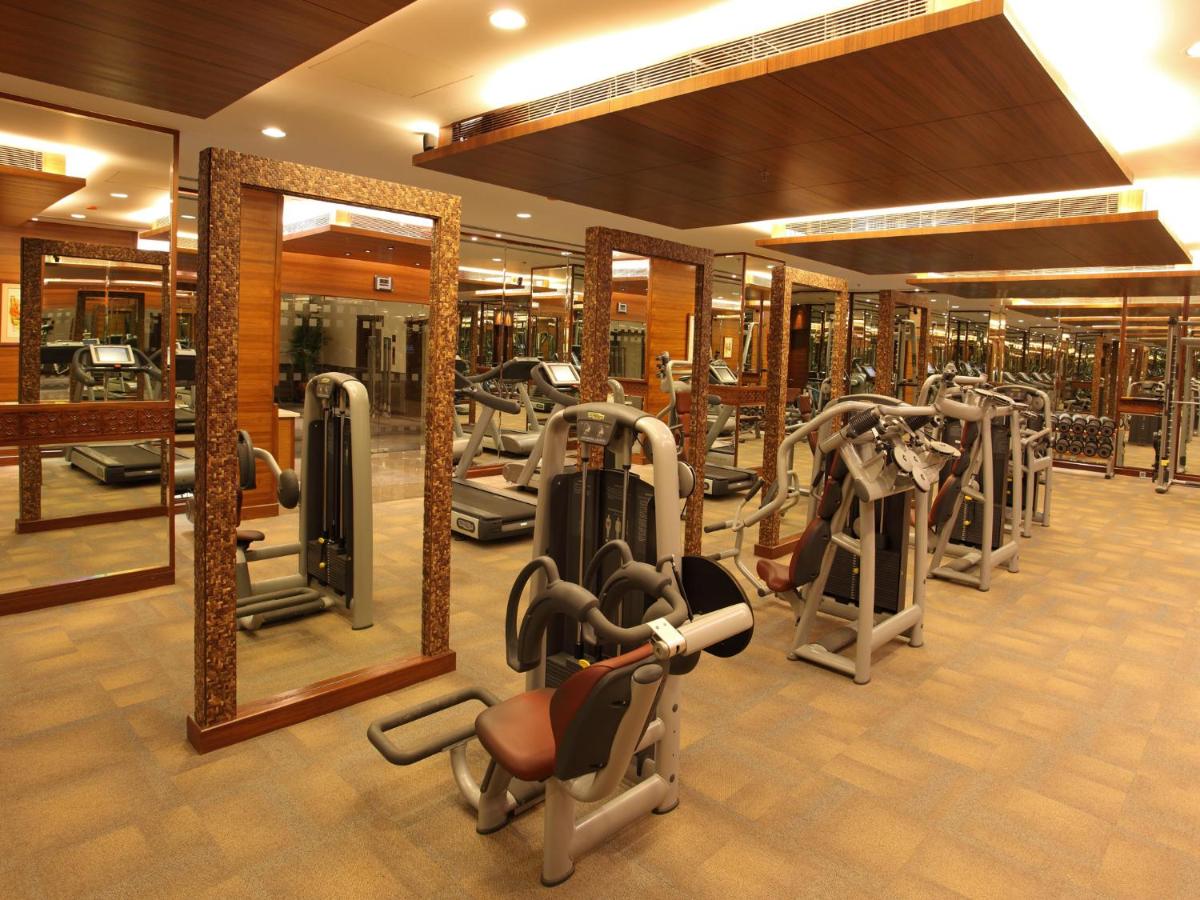 a gym with a row of treadmills and mirrors at The Lalit Mumbai in Mumbai