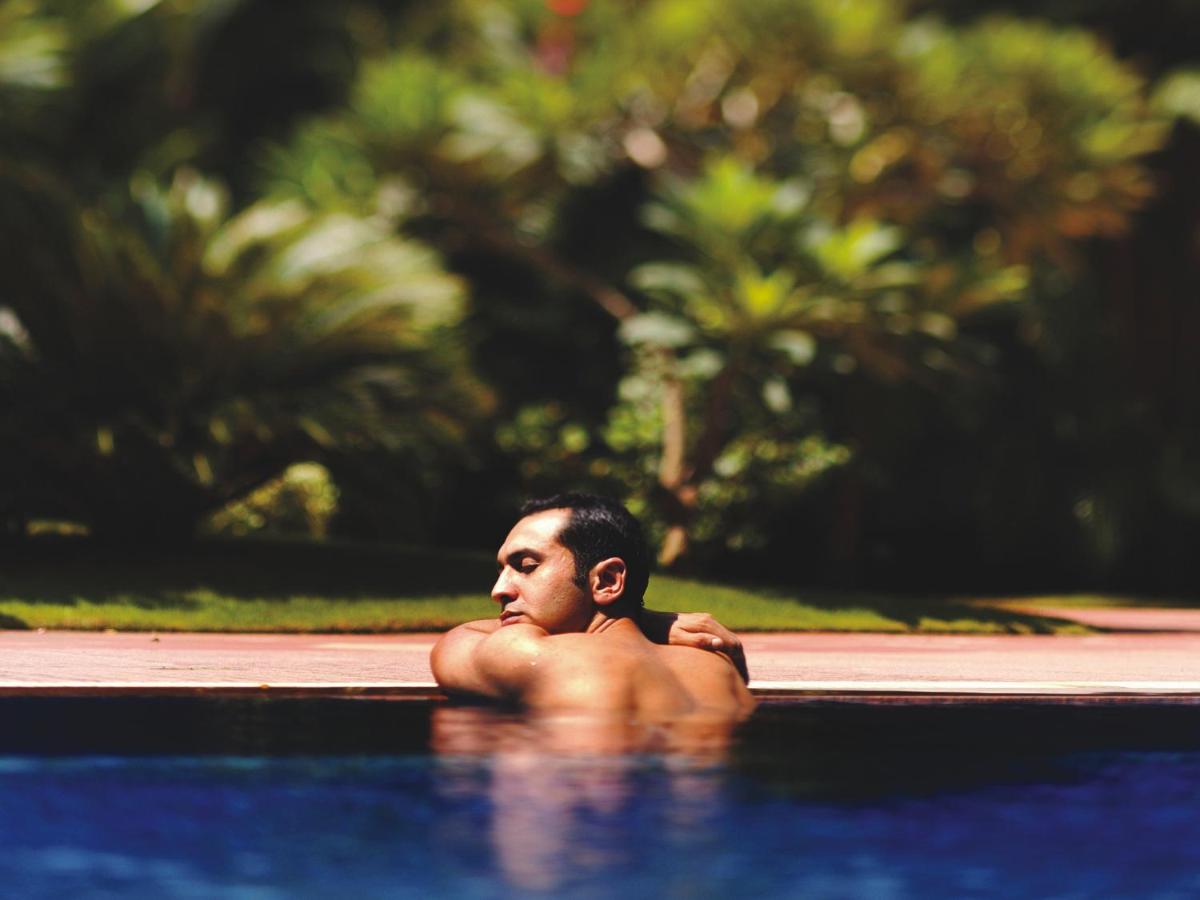 a man swimming in a swimming pool at The Lalit Mumbai in Mumbai