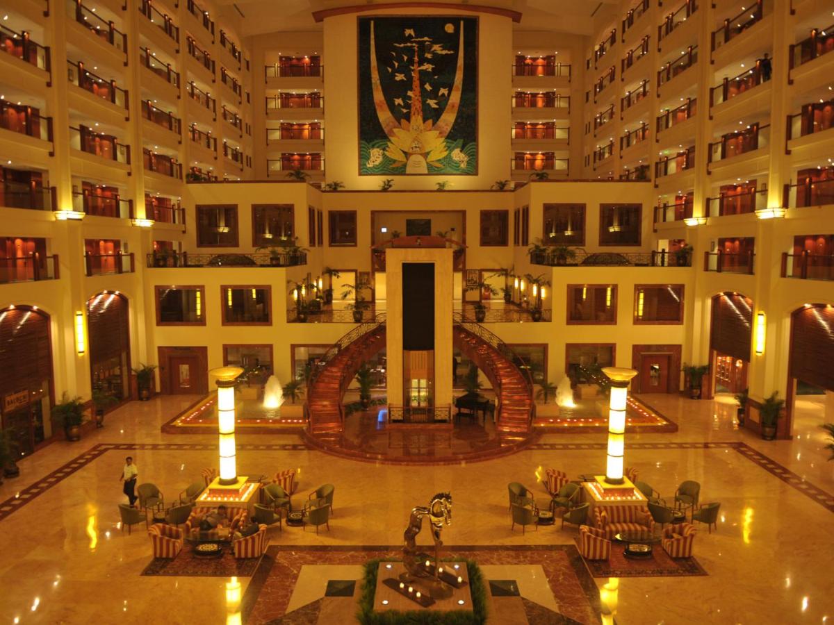 an empty lobby of a hotel with tables and chairs at The Lalit Mumbai in Mumbai