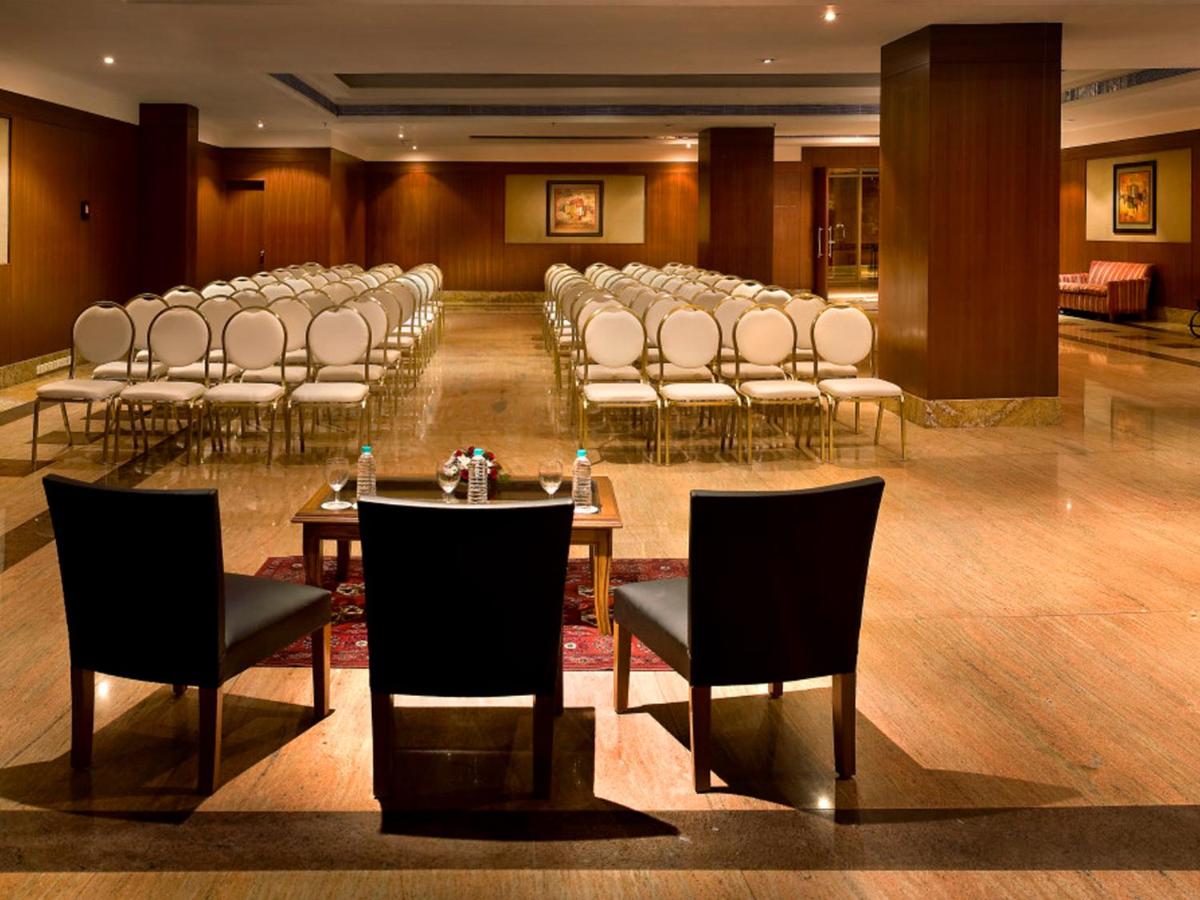 a room with rows of chairs and tables and chairs at The Lalit Mumbai in Mumbai