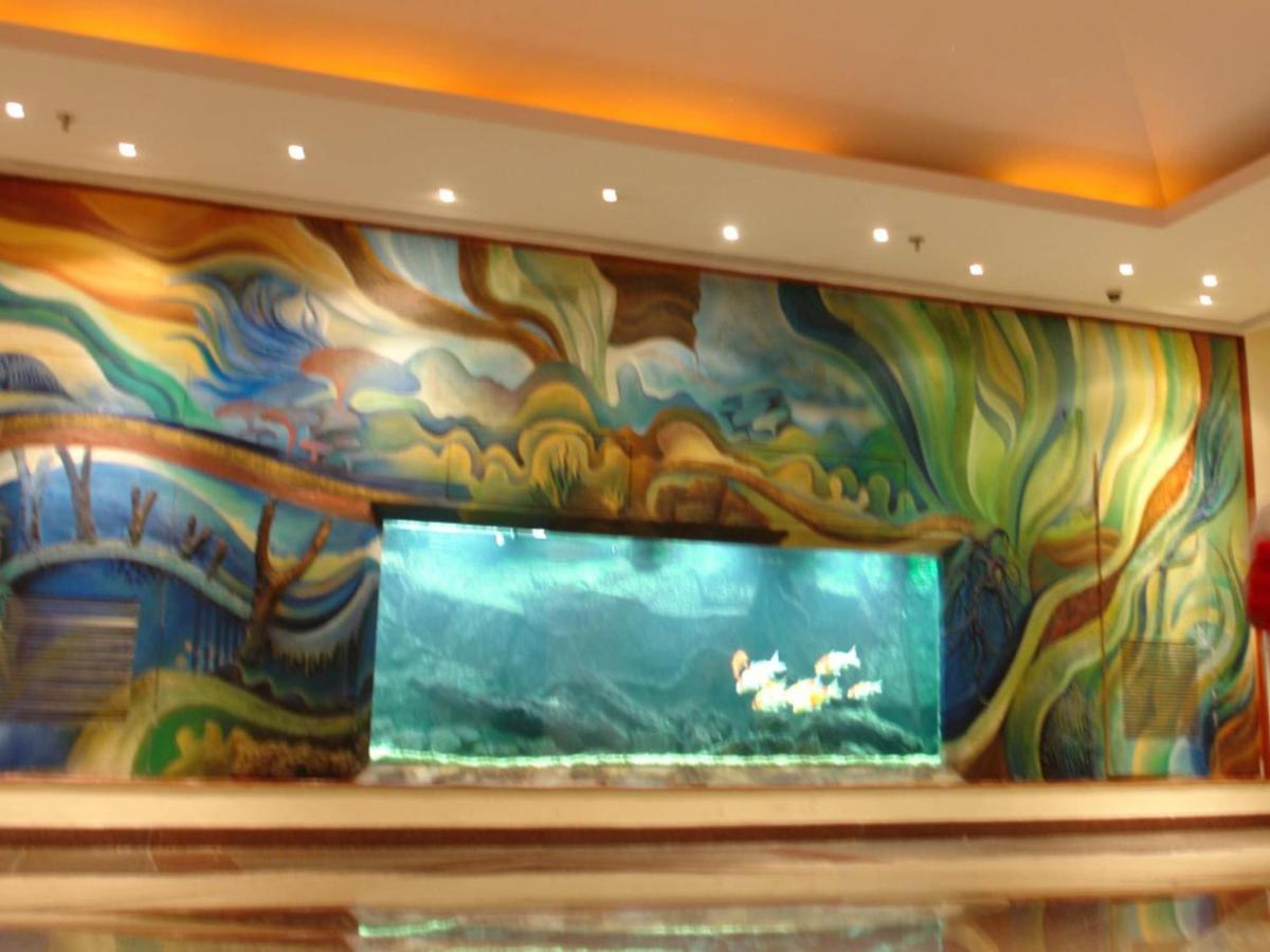 a large aquarium in a room with a colorful wall at The Lalit Mumbai in Mumbai