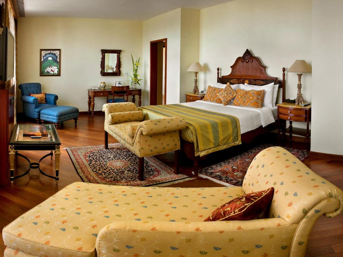 a hotel room with a bed and a couch at The Lalit Mumbai in Mumbai