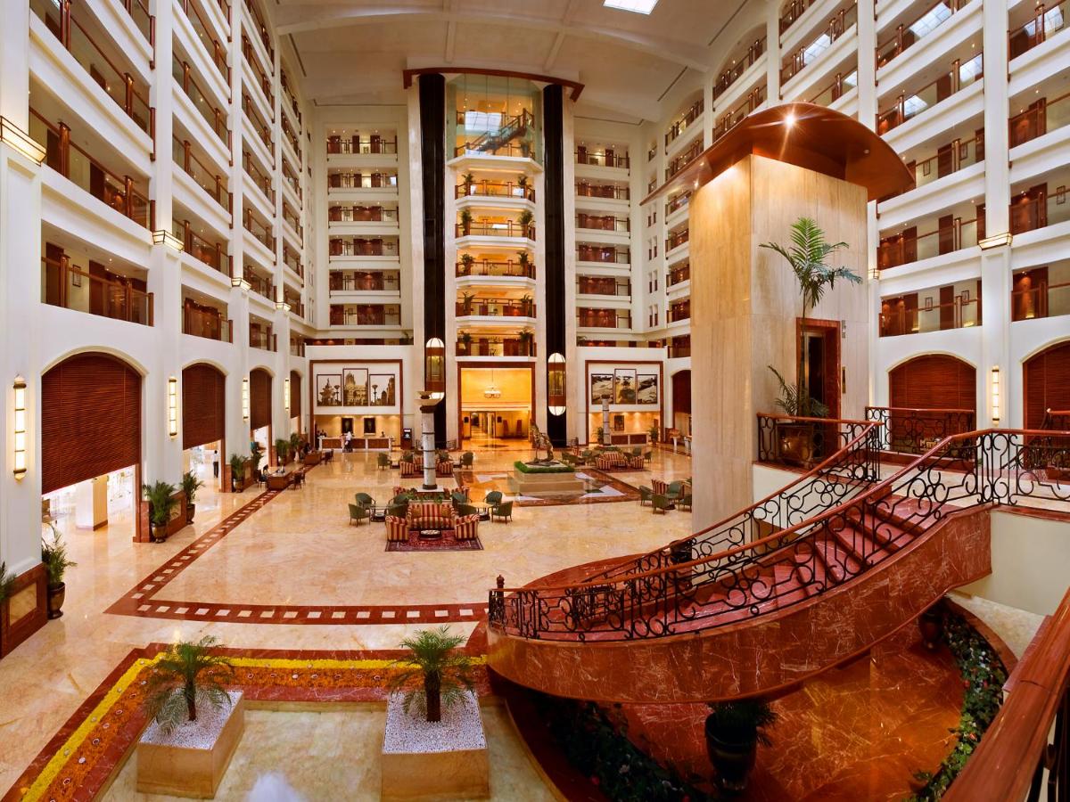 a large lobby with a spiral staircase in a building at The Lalit Mumbai in Mumbai