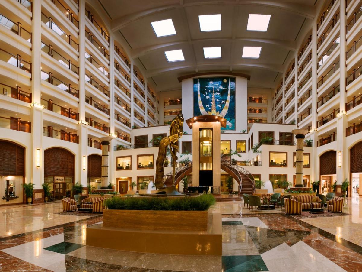 a lobby with a fountain in the middle of a building at The Lalit Mumbai in Mumbai