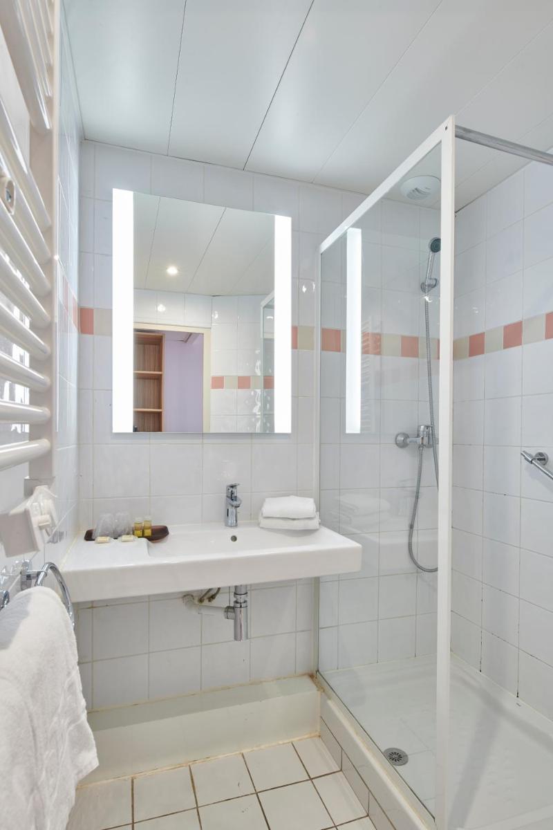 une salle de bain blanche avec un lavabo et une douche dans l'établissement Hotel Club Le Plein Sud Vacances Bleues, à Hyères