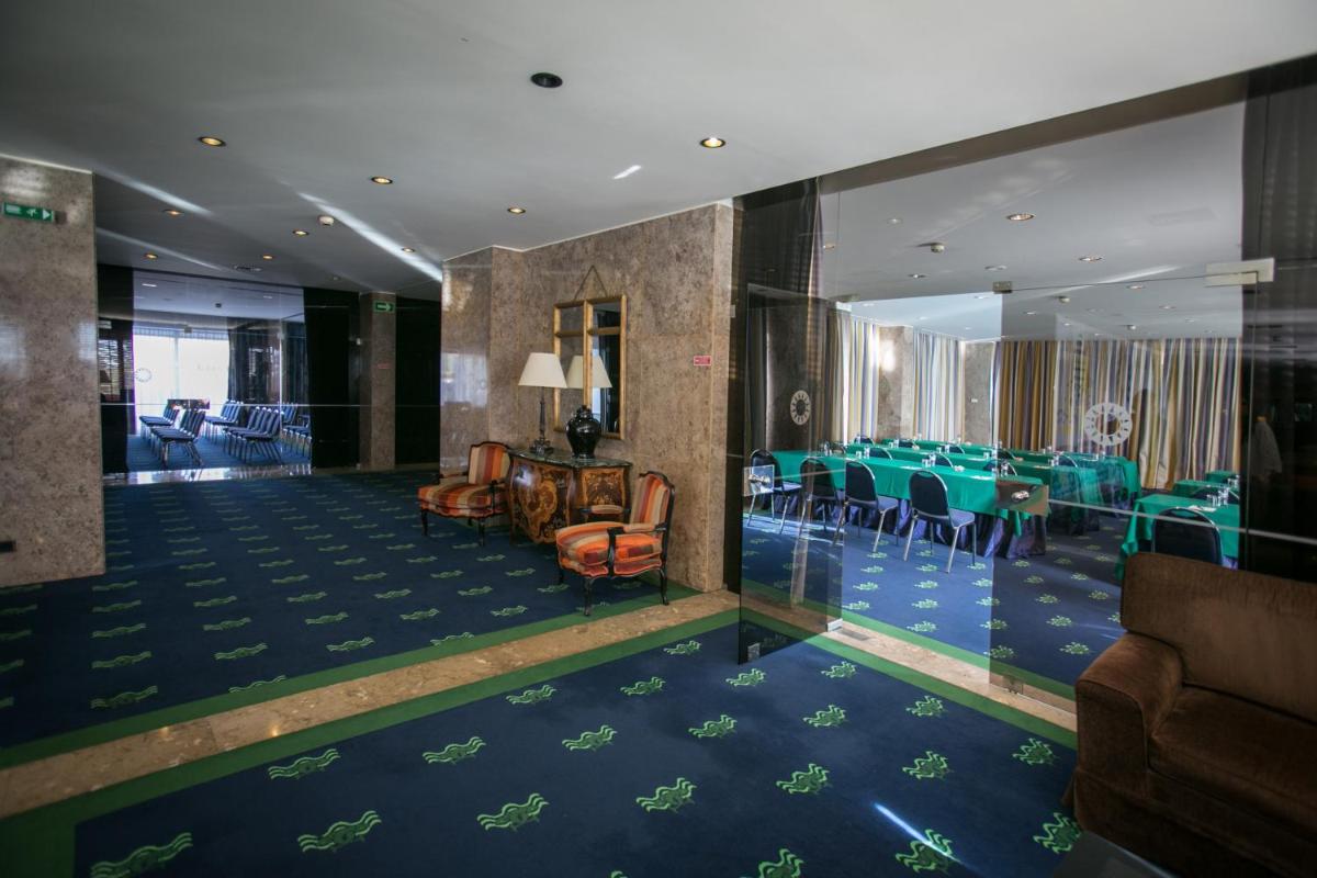 uma sala de jantar com mesas e cadeiras verdes em Hotel Solverde Spa and Wellness Center em Vila Nova de Gaia mais 67 fotografias