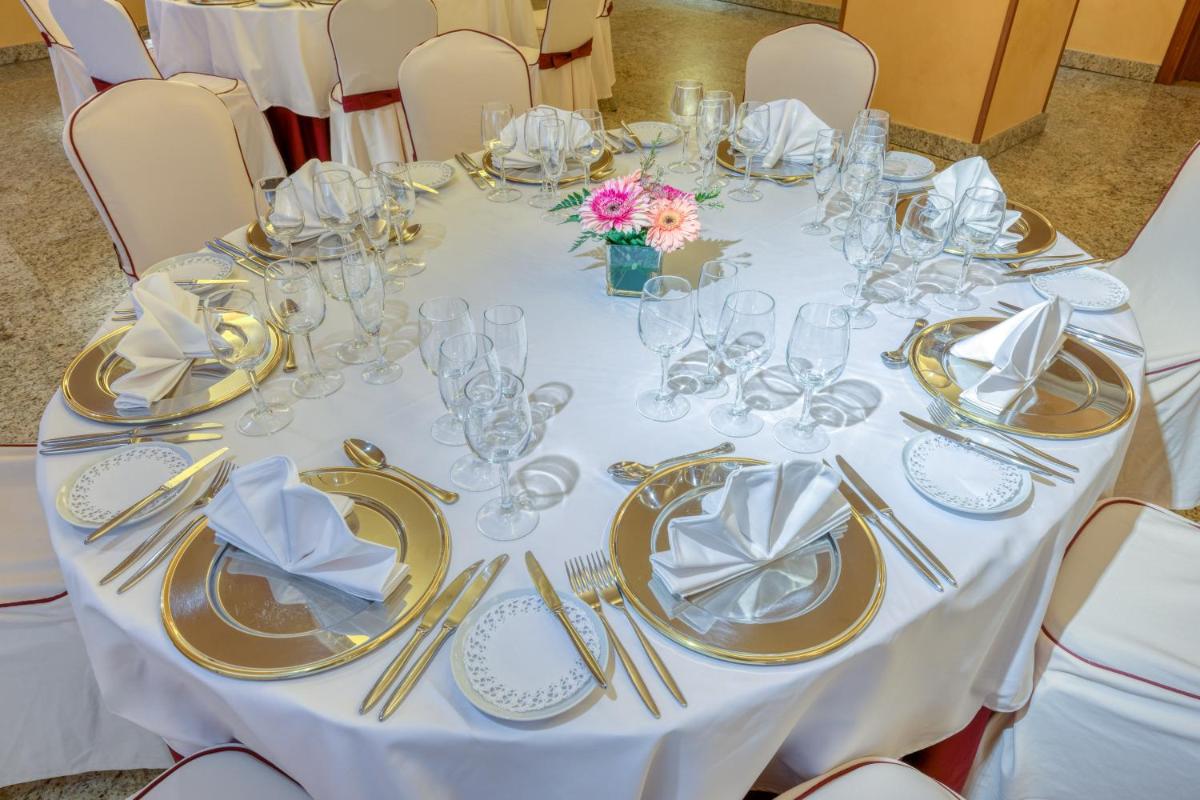 una mesa con vasos, platos y servilletas. en Senator Granada, en Granada 100 fotos más