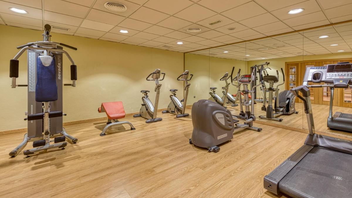 un gimnasio con varias cintas de correr y bicicletas estáticas en Senator Granada, en Granada