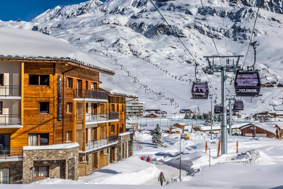 un lodge de ski dans la neige avec une remontée mécanique dans l'établissement Résidence Daria-I Nor by les Etincelles, à L'Alpe-d'Huez