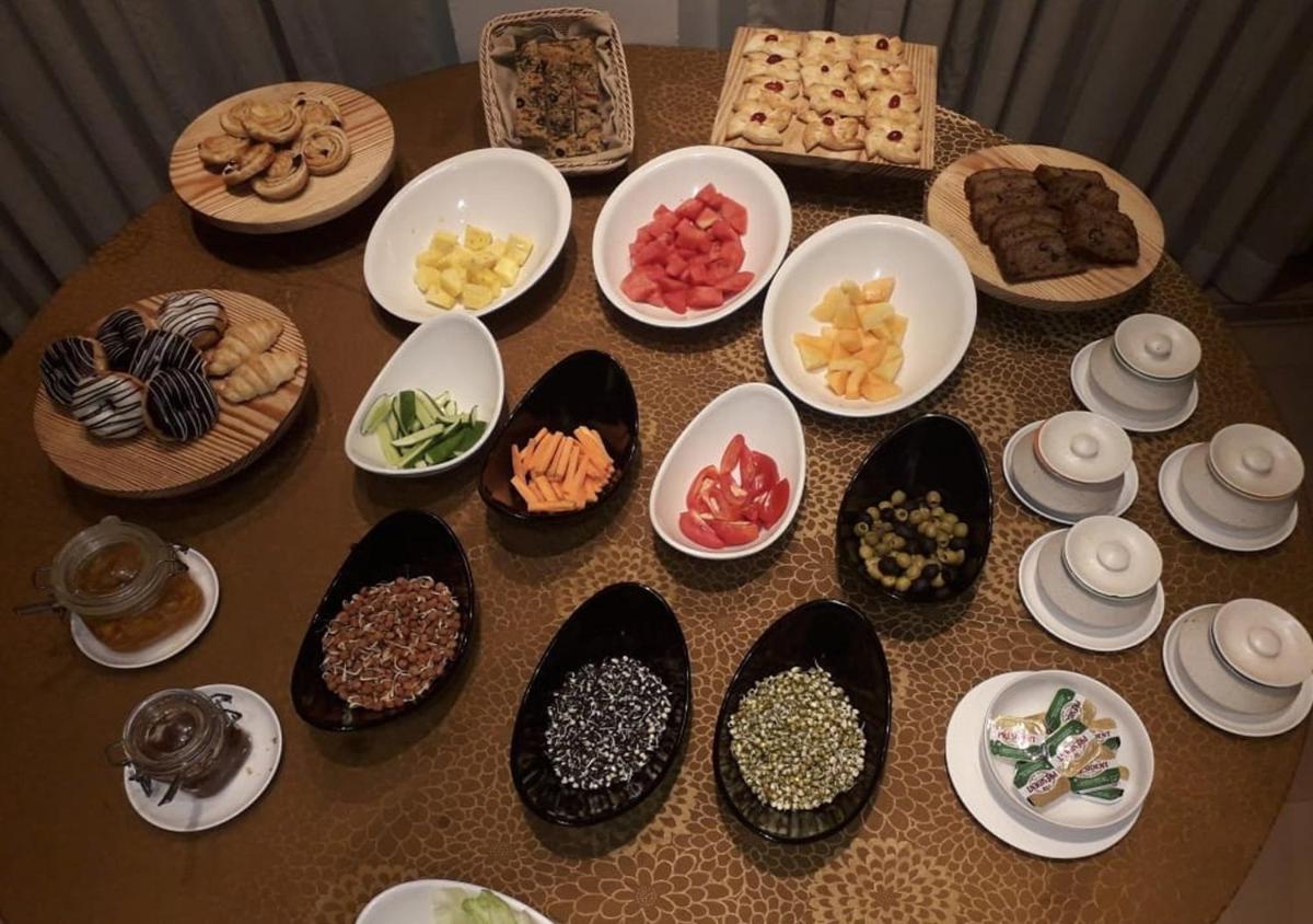 a table topped with plates and bowls of food at Fragrant Nature Kochi - A Five star Classified Hotel in Cochin