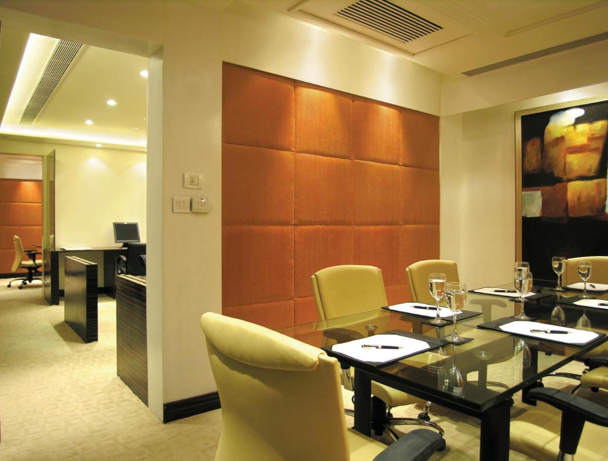 a restaurant with a table and chairs and a desk at Taj Chandigarh in Chandīgarh
