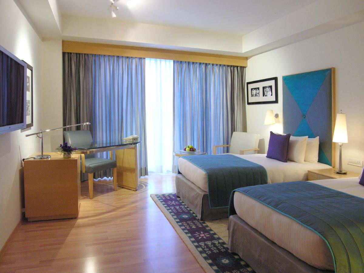 a hotel room with two beds and a desk at Taj Chandigarh in Chandīgarh