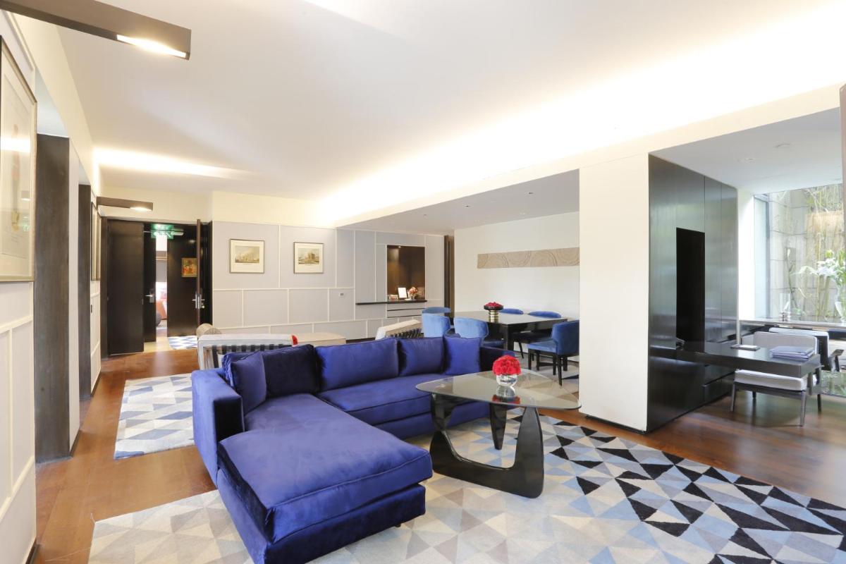a living room with a blue couch and a table at The Lodhi – A member of The Leading Hotels Of The World in New Delhi