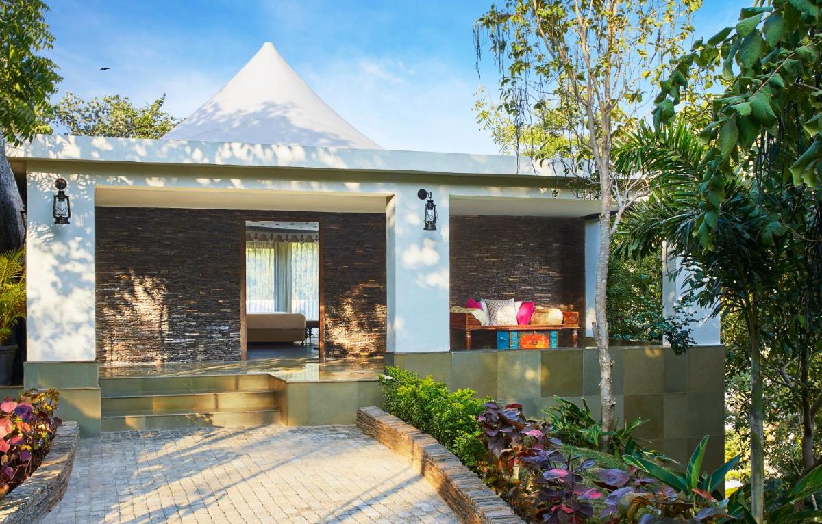 a house with a mountain in the background at Taj Aravali Resort & Spa Udaipur in Udaipur