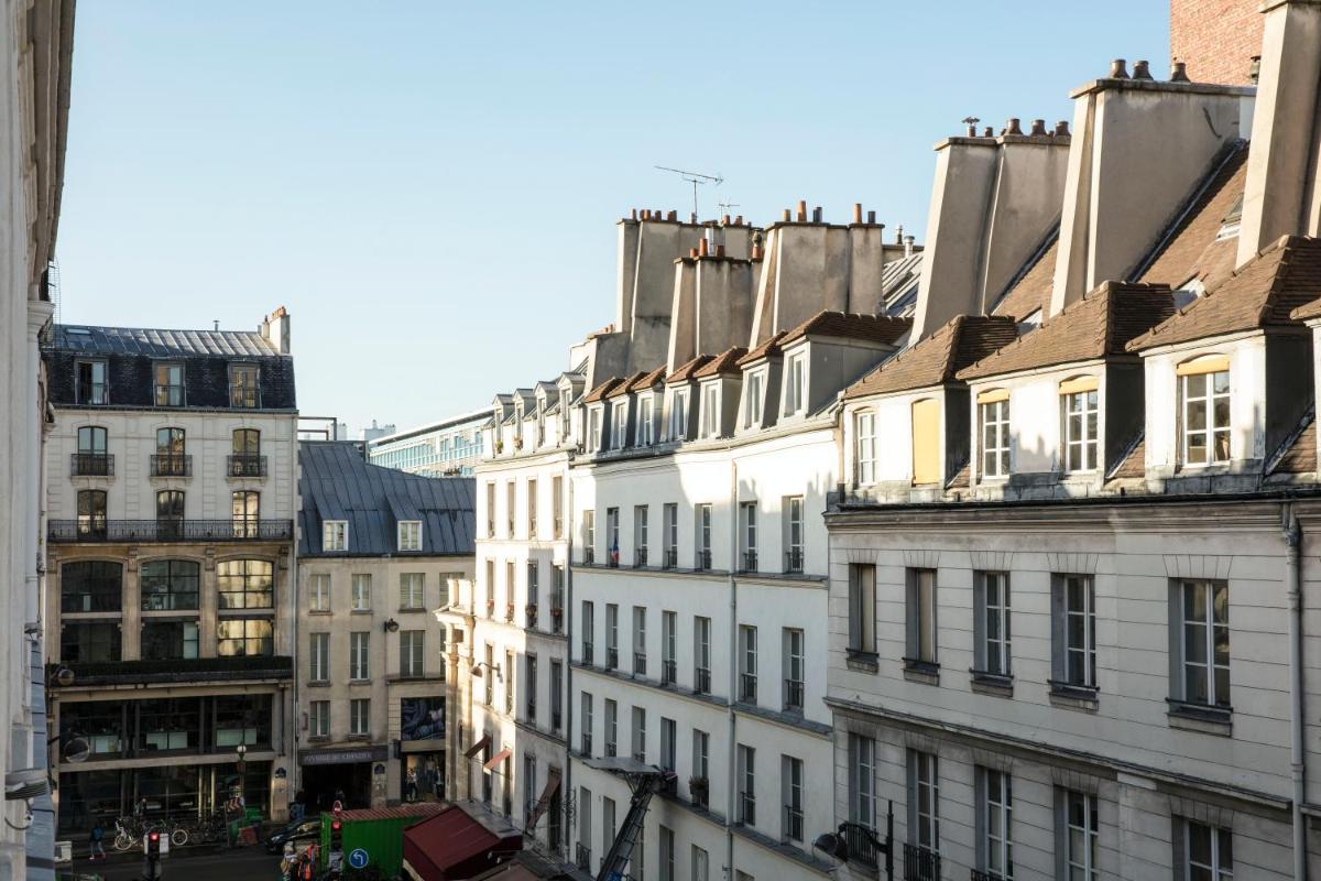 une rangée de bâtiments blancs dans une ville dans l'établissement Hotel L’Antoine, à Paris