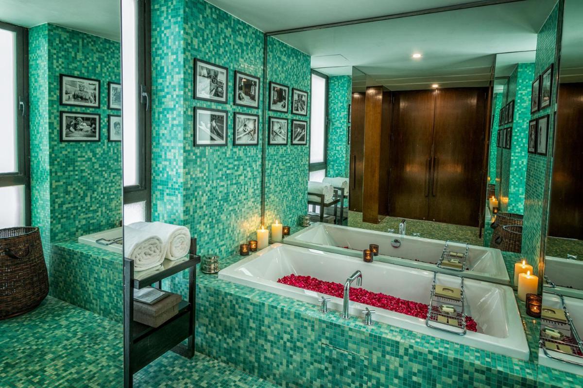 a bathroom with a tub with blue tiles at The Lodhi – A member of The Leading Hotels Of The World in New Delhi