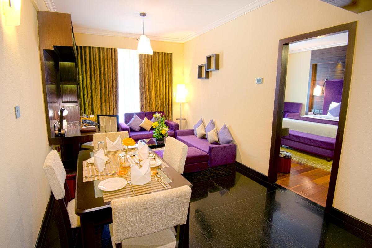 a room with a dining table and a living room at Sterlings Mac Hotel in Bengaluru