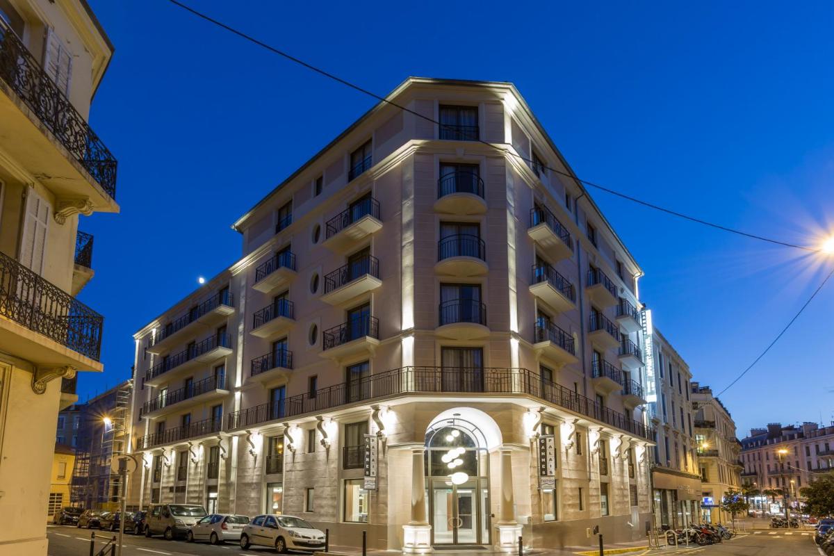 un grand bâtiment blanc sur une rue de la ville la nuit dans l'établissement Nemea Appart Hotel Cannes Palais, à Cannes