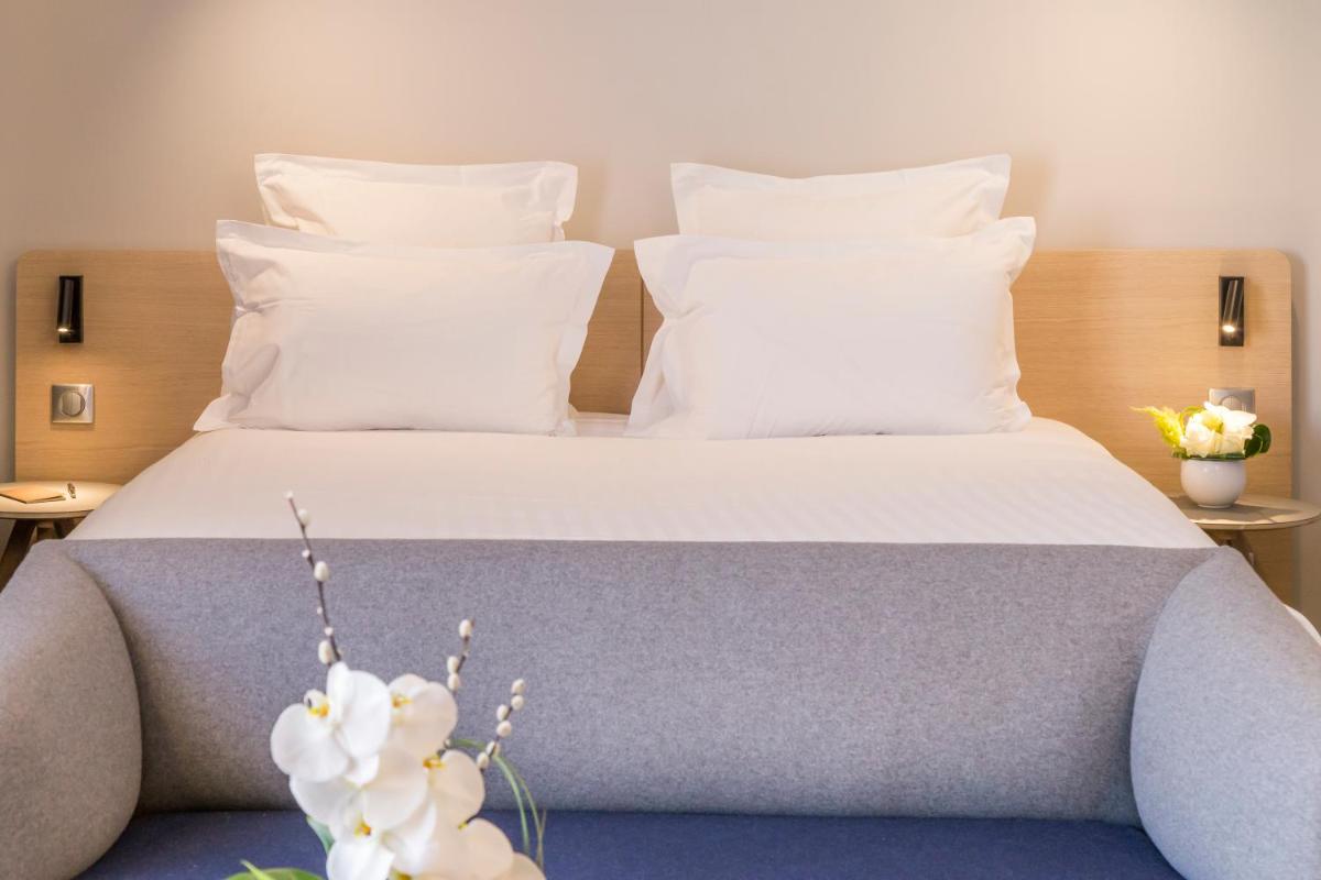 Un ou plusieurs lits dans un hébergement de l'établissement Nemea Appart Hotel Cannes Palais