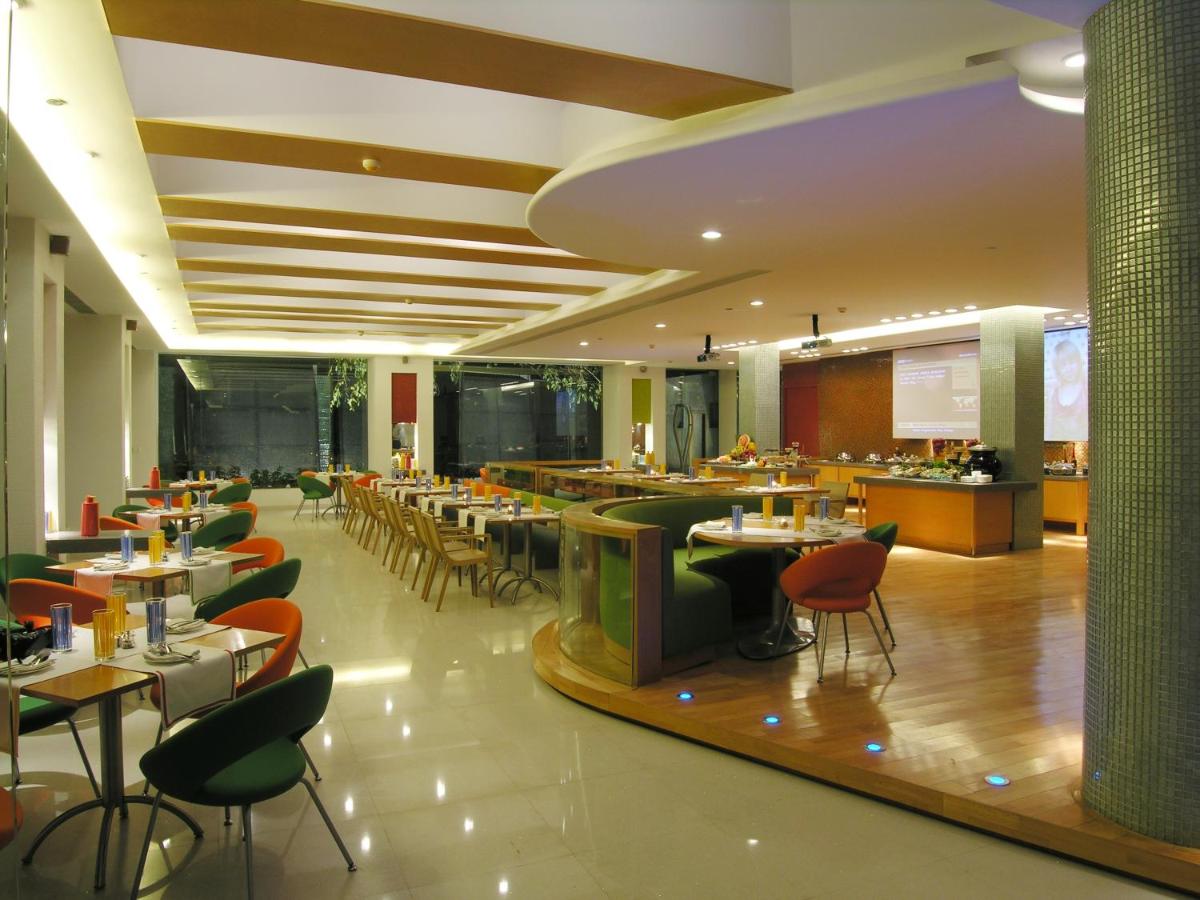 a restaurant with tables and chairs and a bar at Taj Chandigarh in Chandīgarh