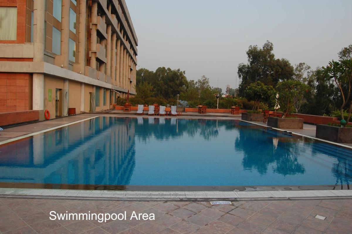 a large blue swimming pool next to a building at Taj Chandigarh in Chandīgarh