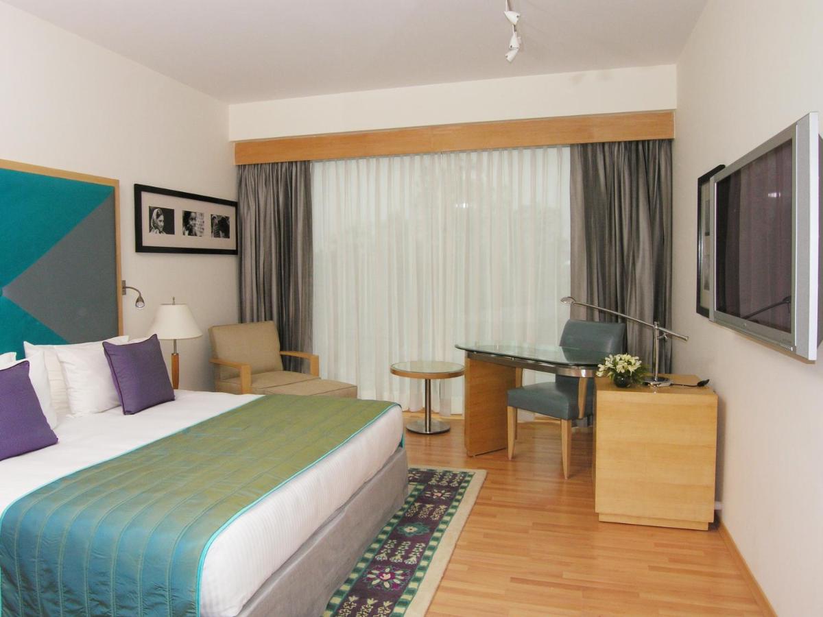 a hotel room with a bed and a desk at Taj Chandigarh in Chandīgarh