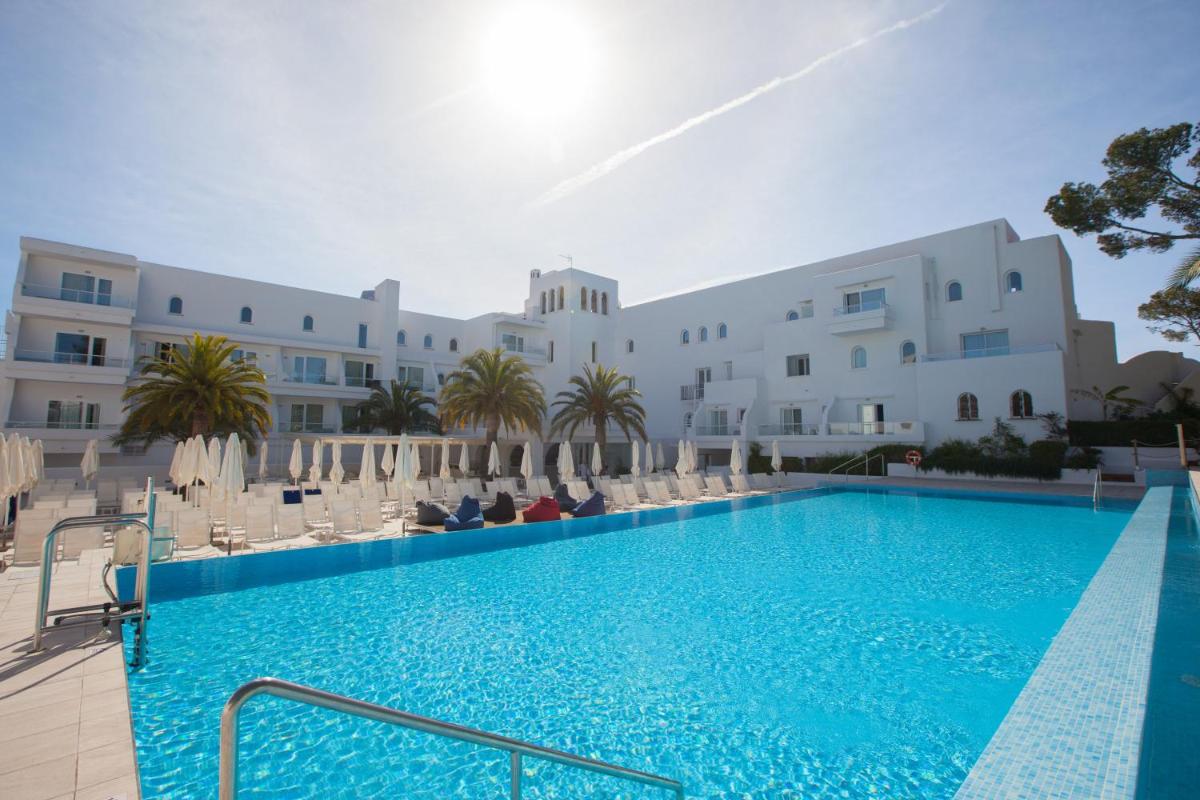 una piscina frente a un gran edificio blanco en Grupotel Rocador - Adults Only, en Cala d´Or