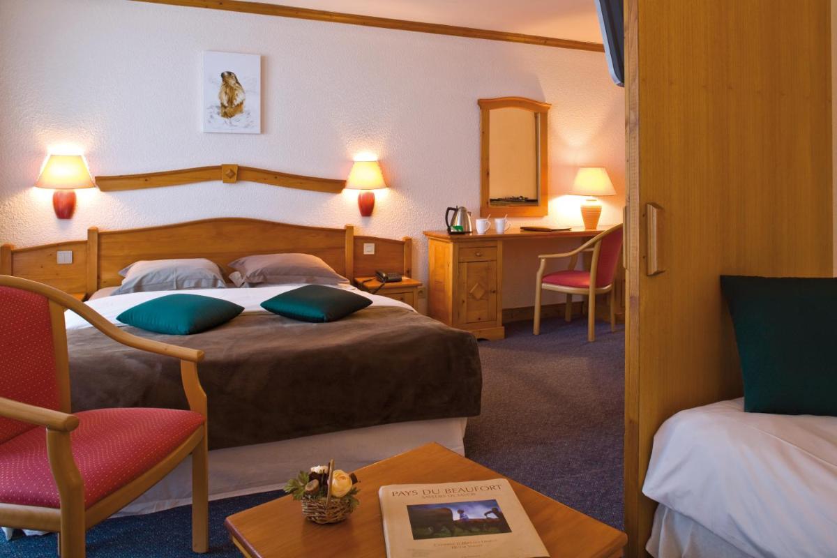 une chambre d'hôtel avec deux lits et un bureau dans l'établissement Le Calgary, aux Saisies 66 autres photos