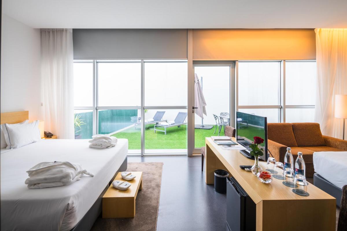 um quarto de hotel com duas camas e uma escrivaninha com um computador em Boticas Hotel Art & SPA em Boticas
