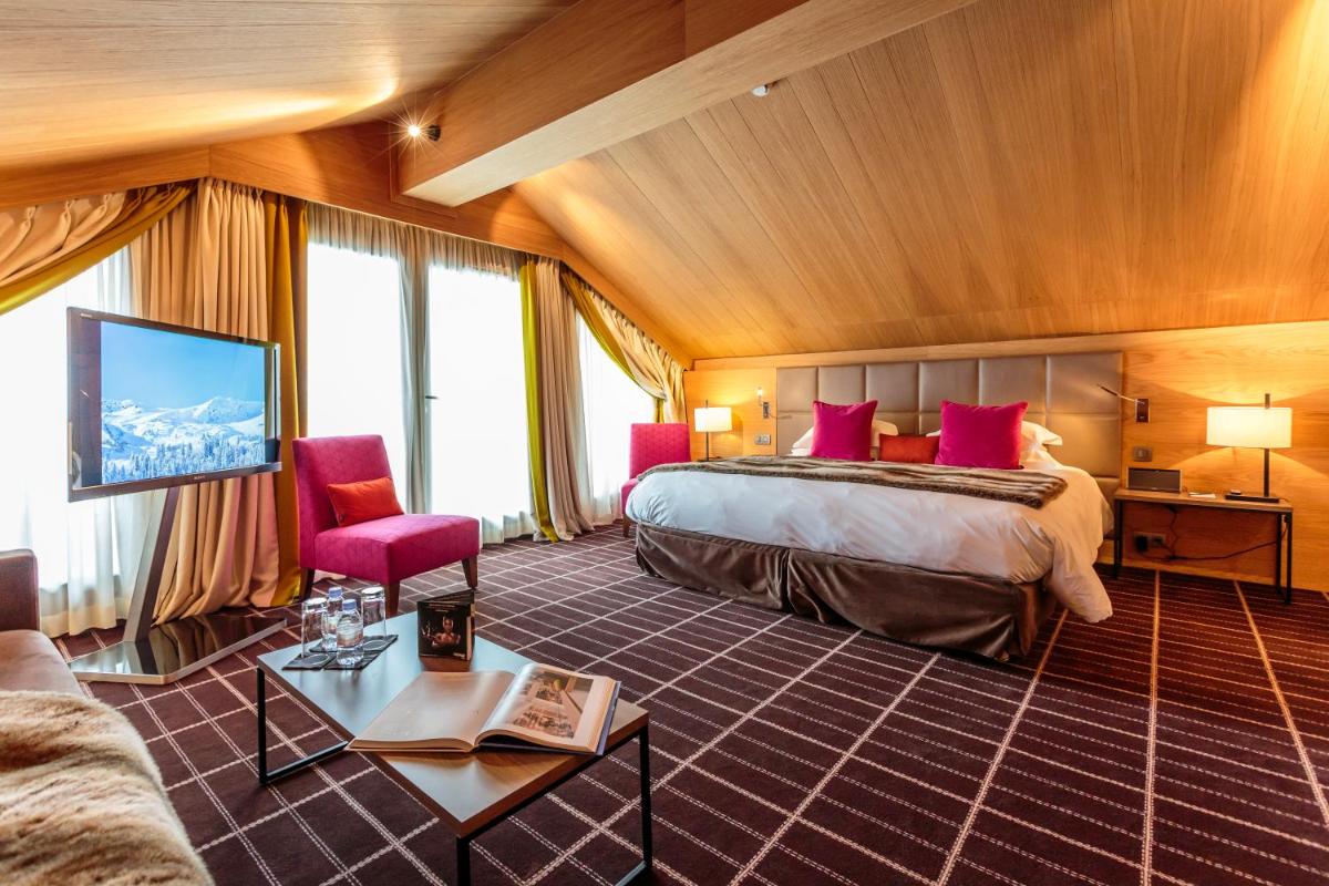 une chambre d'hôtel avec un lit et une télévision dans l'établissement Hotel Le Savoy, à Méribel