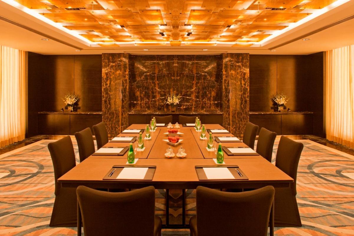 a conference room with a long table and chairs at Radisson Blu Plaza Delhi Airport in New Delhi a conference room with a long table and chairs at Radisson Blu Plaza Delhi Airport in New Delhi