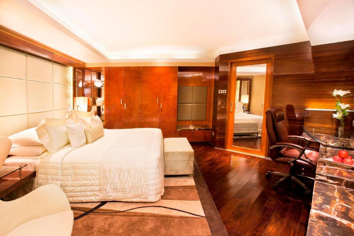 a bedroom with a bed and a living room at Radisson Blu Plaza Delhi Airport in New Delhi a bedroom with a bed and a living room at Radisson Blu Plaza Delhi Airport in New Delhi