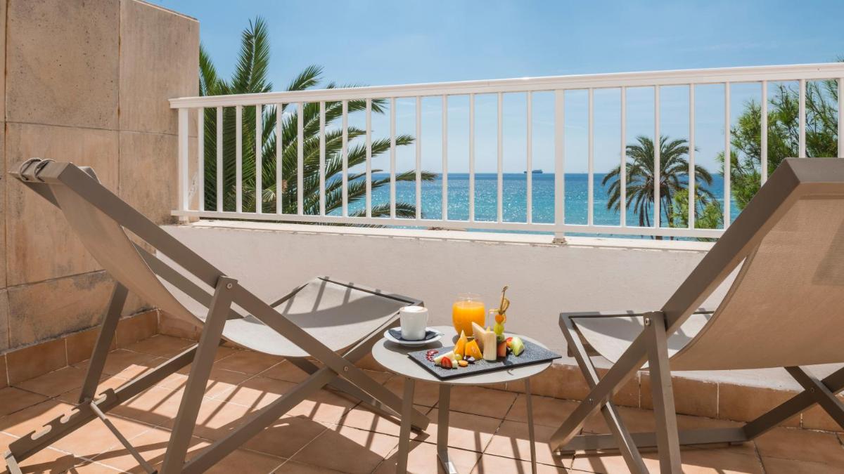 Una mesa y sillas en un balcón con vista al mar. en Be Live Adults Only La Cala Boutique Hotel, en Palma de Mallorca