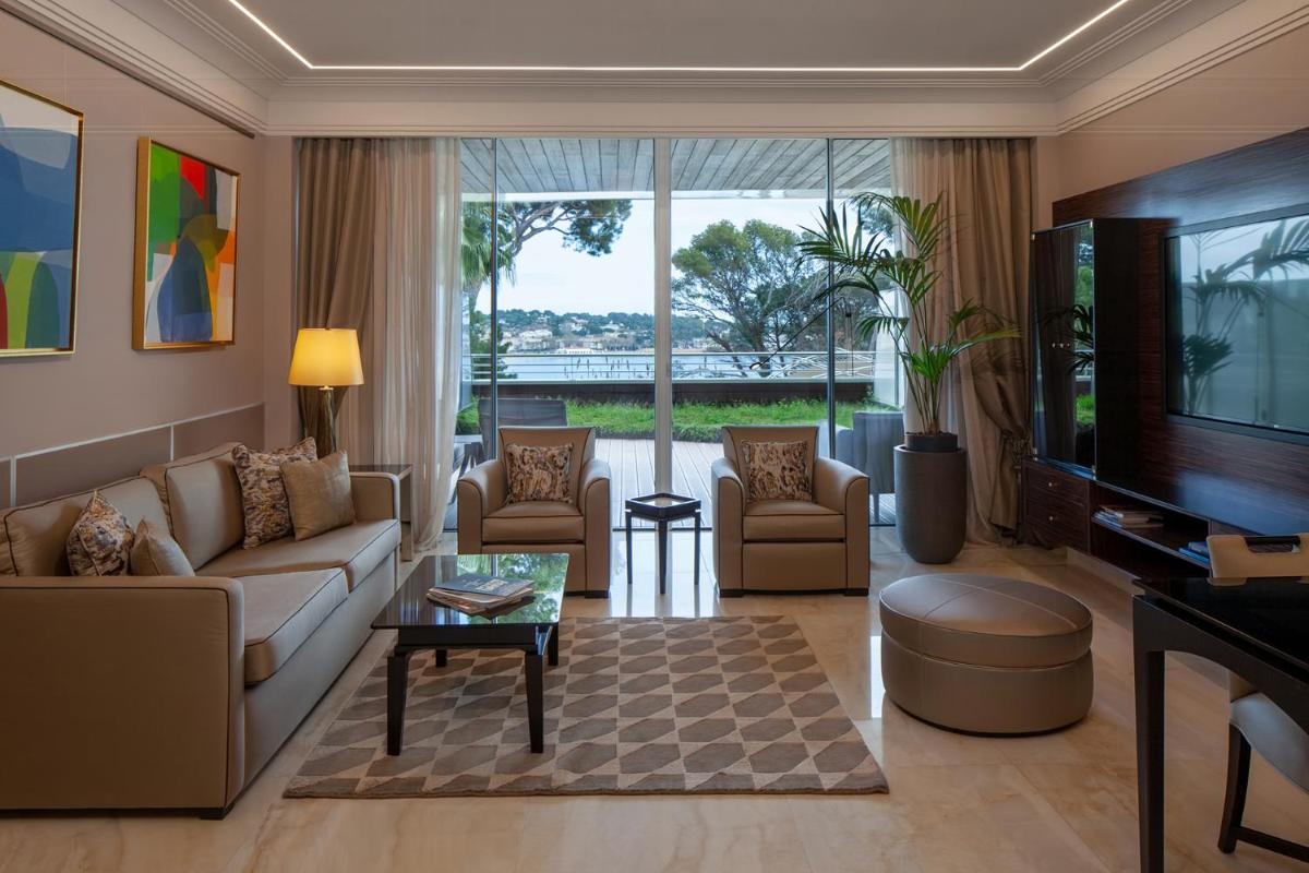 Una sala de estar con un sofá y sillas y un televisor. en Alàbriga Hotel GL, en S'Agaró