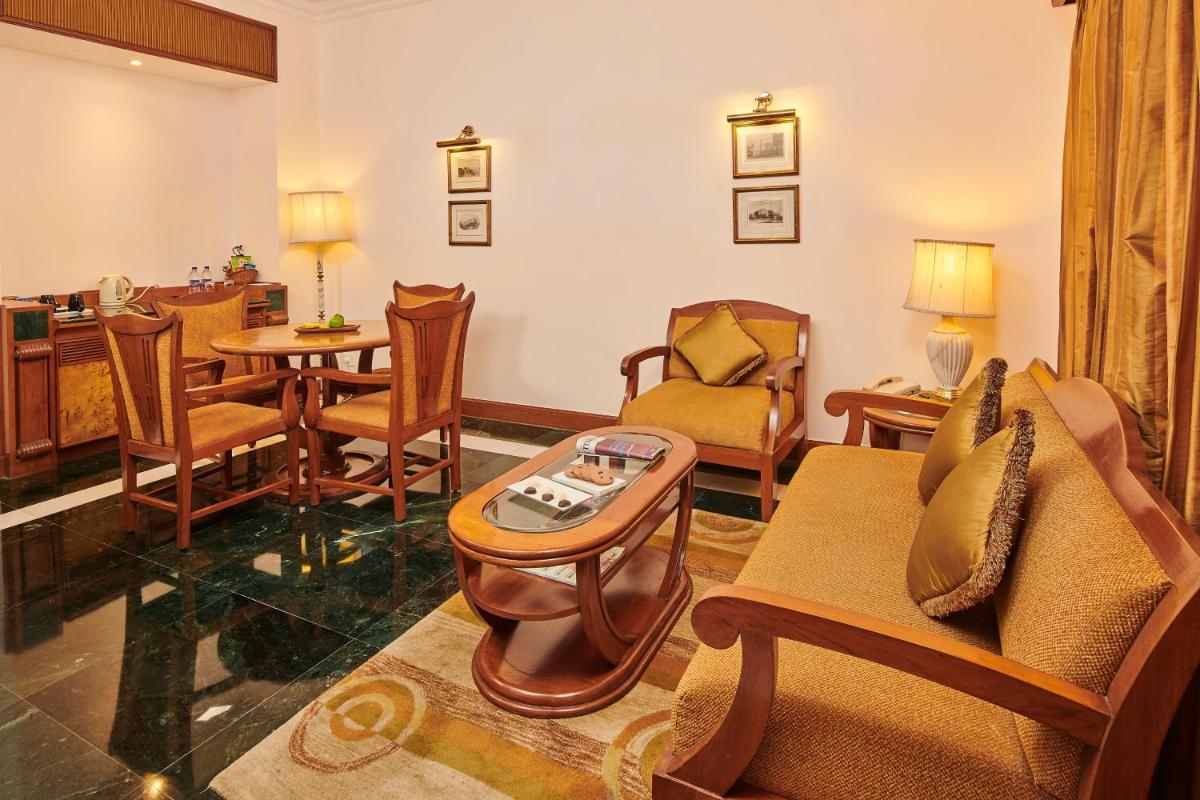 a living room with a couch and chairs and a table at The Ummed Ahmedabad Airport in Ahmedabad