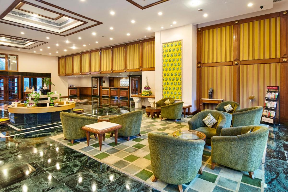 a lobby with couches and chairs and a table at The Ummed Ahmedabad Airport in Ahmedabad