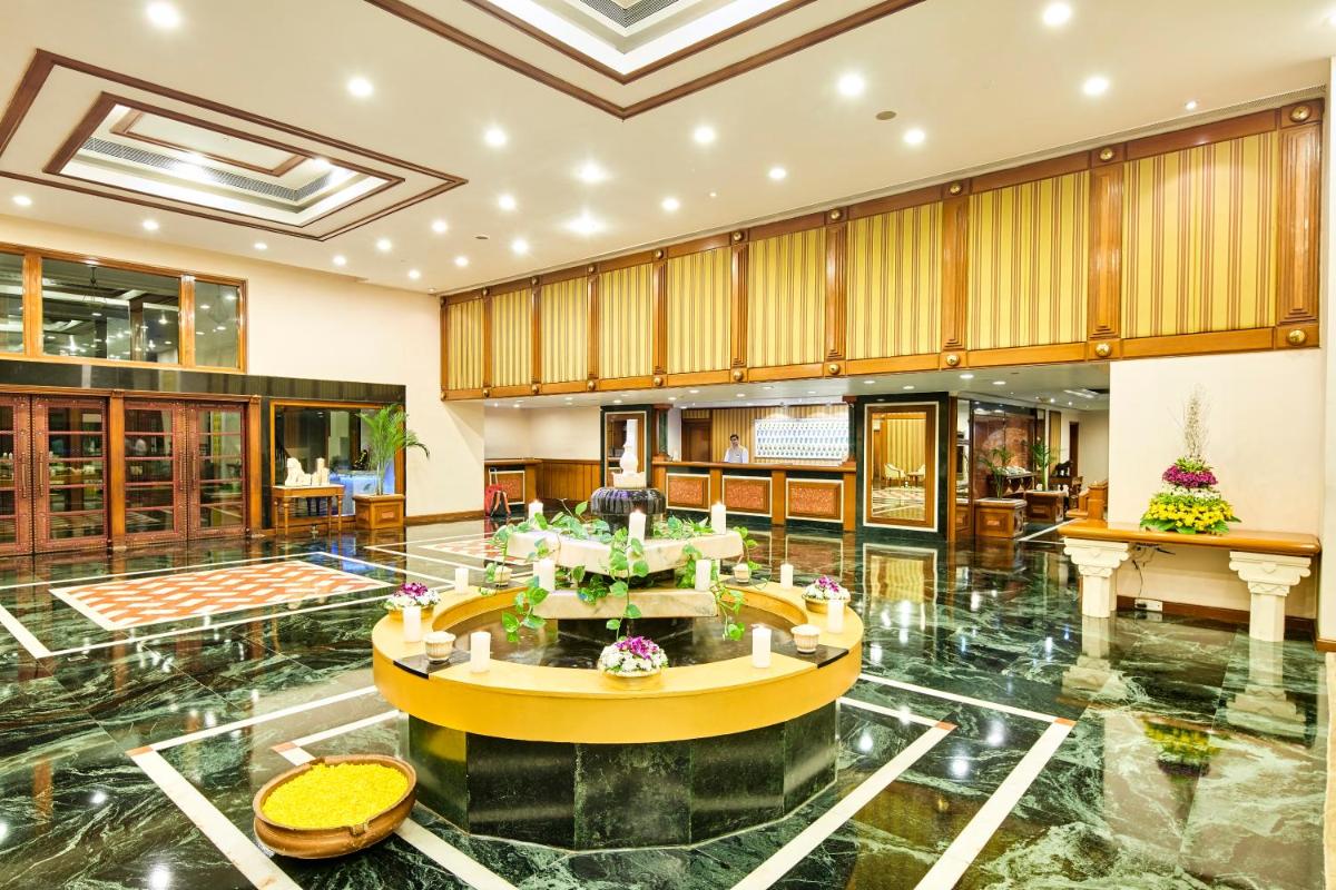 a large lobby with a round table in the middle at The Ummed Ahmedabad Airport in Ahmedabad +29 photos