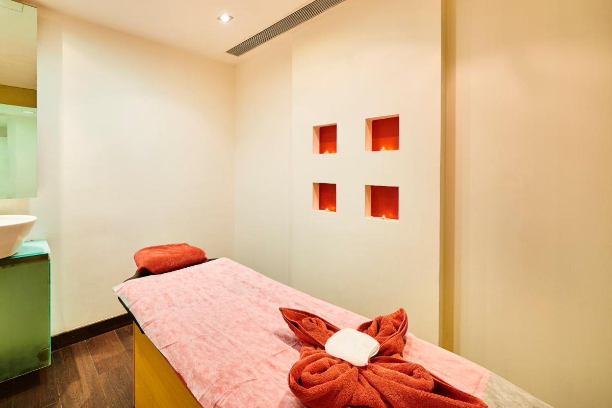 a bedroom with a bed with a towel on it at The Ummed Ahmedabad Airport in Ahmedabad