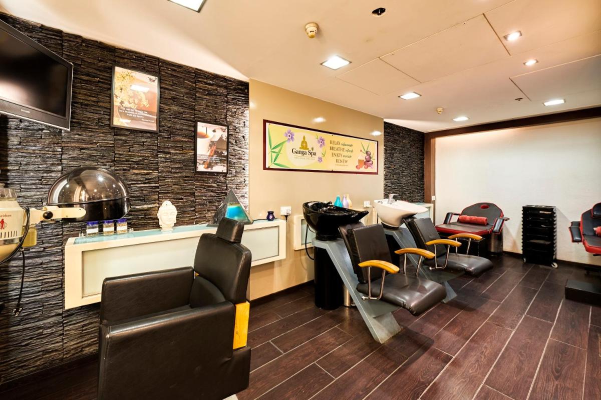 a waiting room with chairs and a barber shop at The Ummed Ahmedabad Airport in Ahmedabad