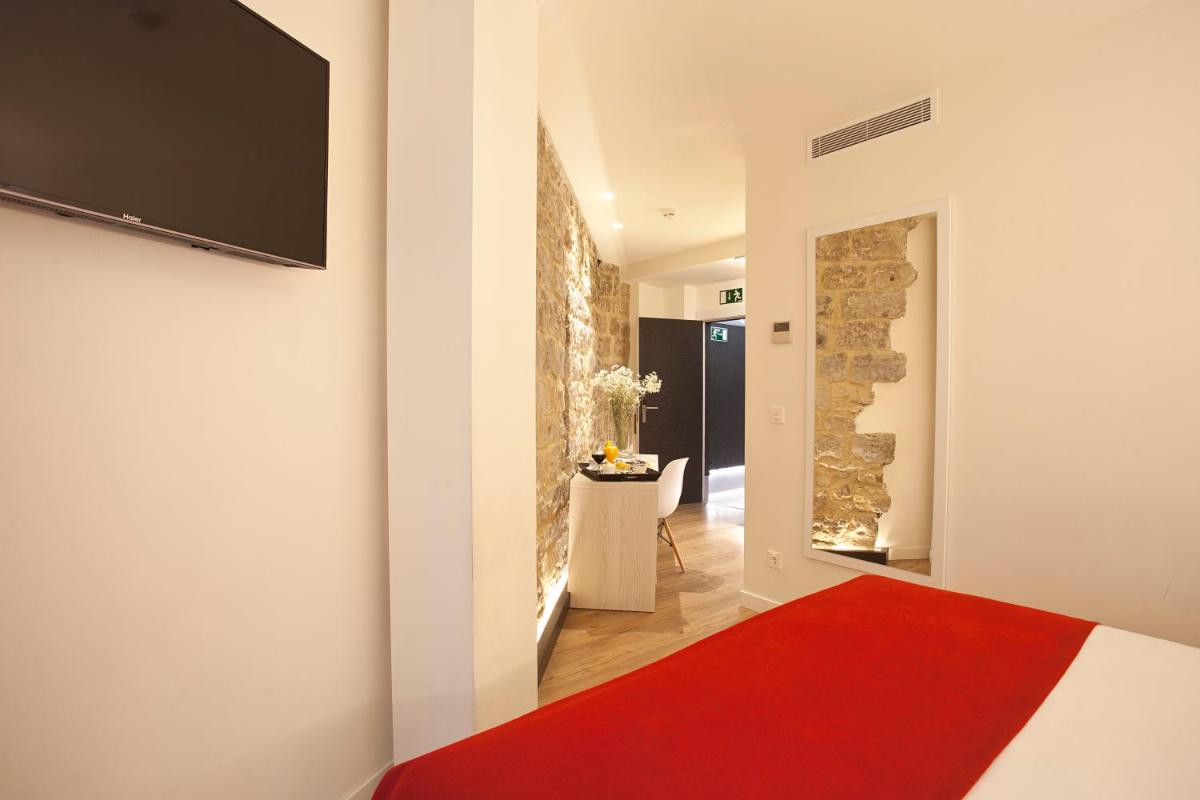 Una televisión o centro de entretenimiento en Hotel Pompaelo Plaza del Ayuntamiento & Spa